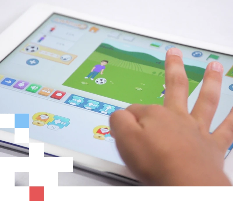タブレットでScratchをする子供の手